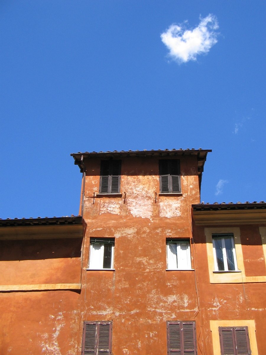 there is a cloud floating in the sky over a building