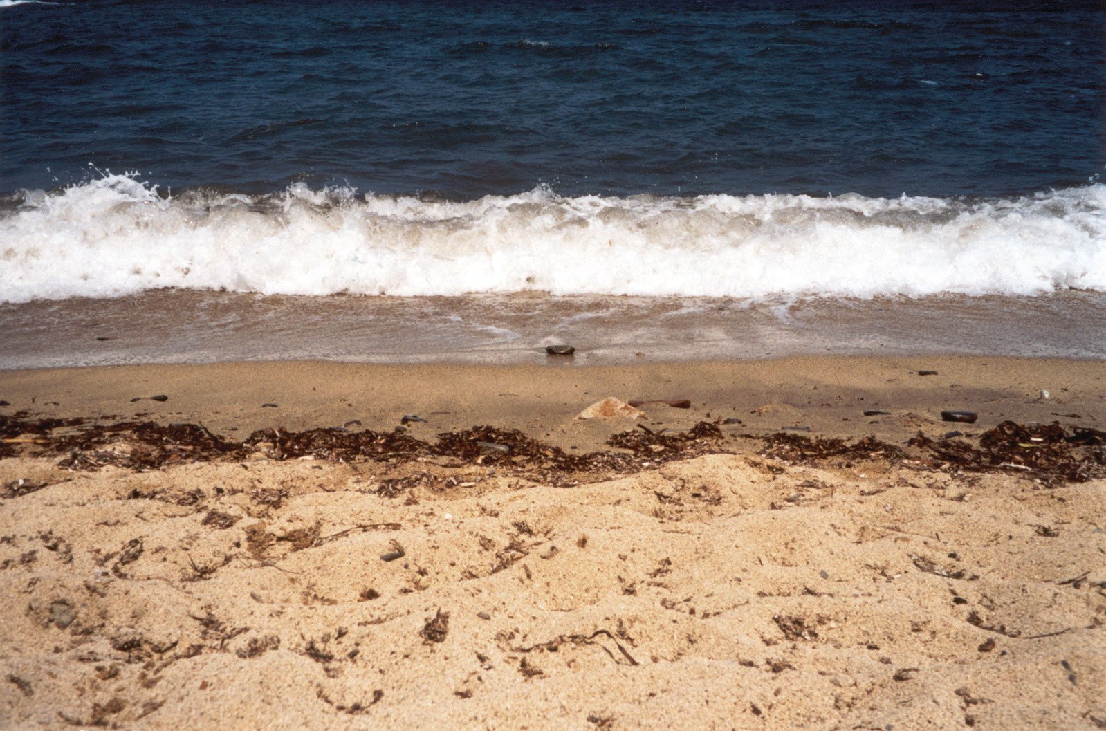 a sandy beach with waves coming in to the shore