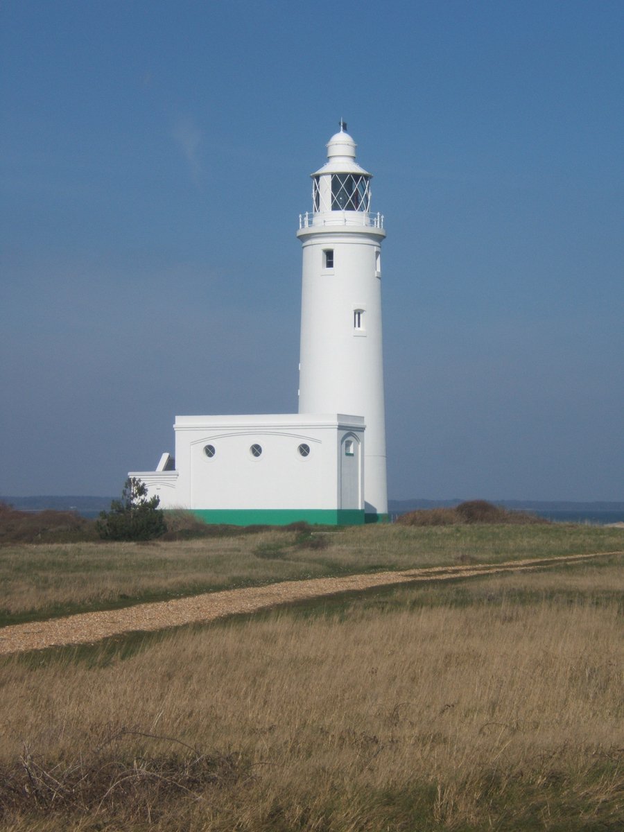 the lighthouse is sitting alone in the tall grass