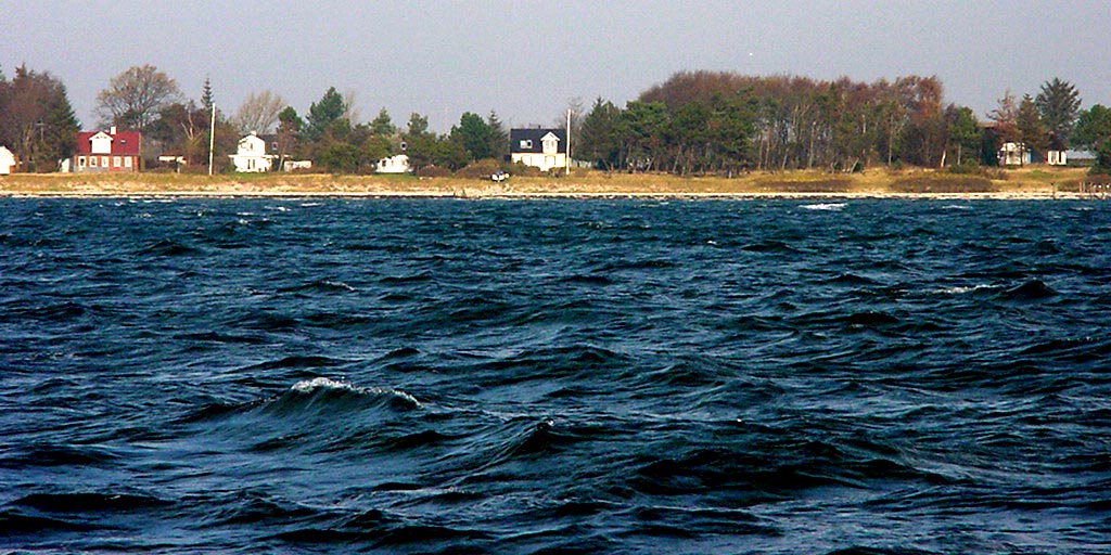 some houses on the shoreline and in the distance the water