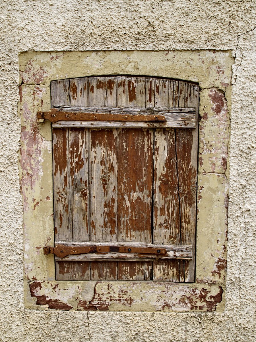 an old window with broken shutters on an old building