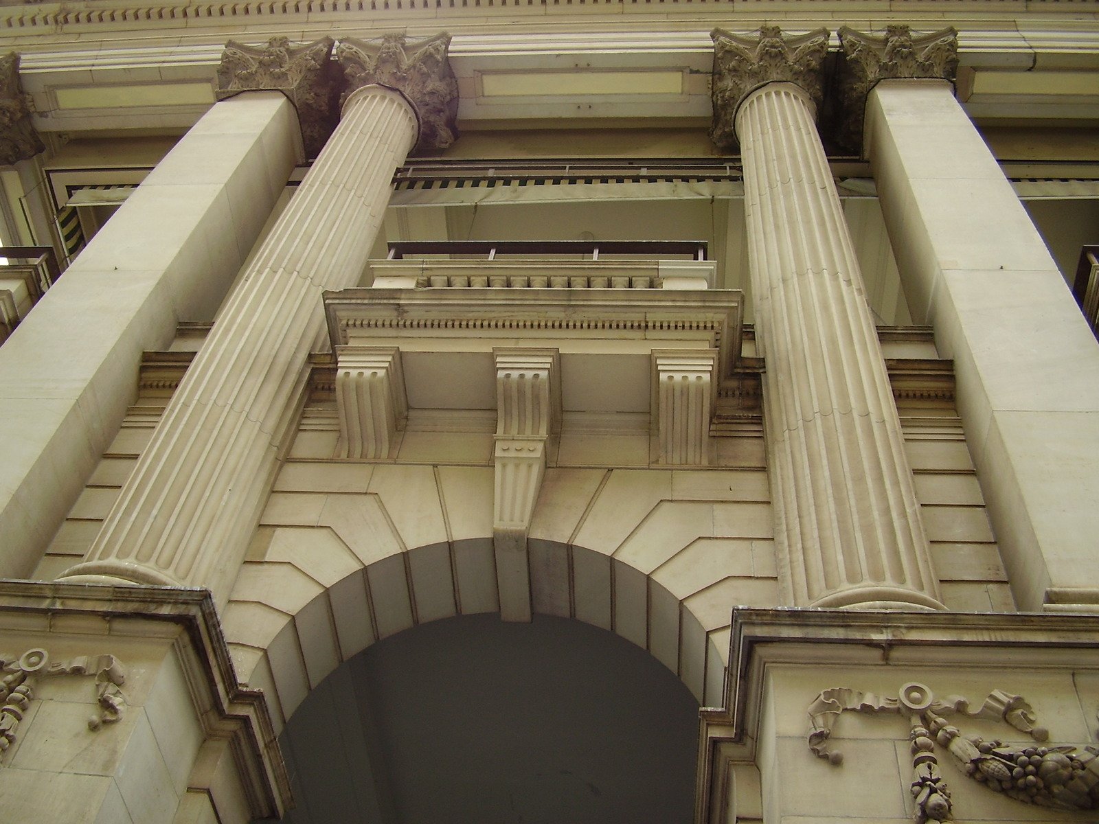 a very tall white building with pillars and a clock