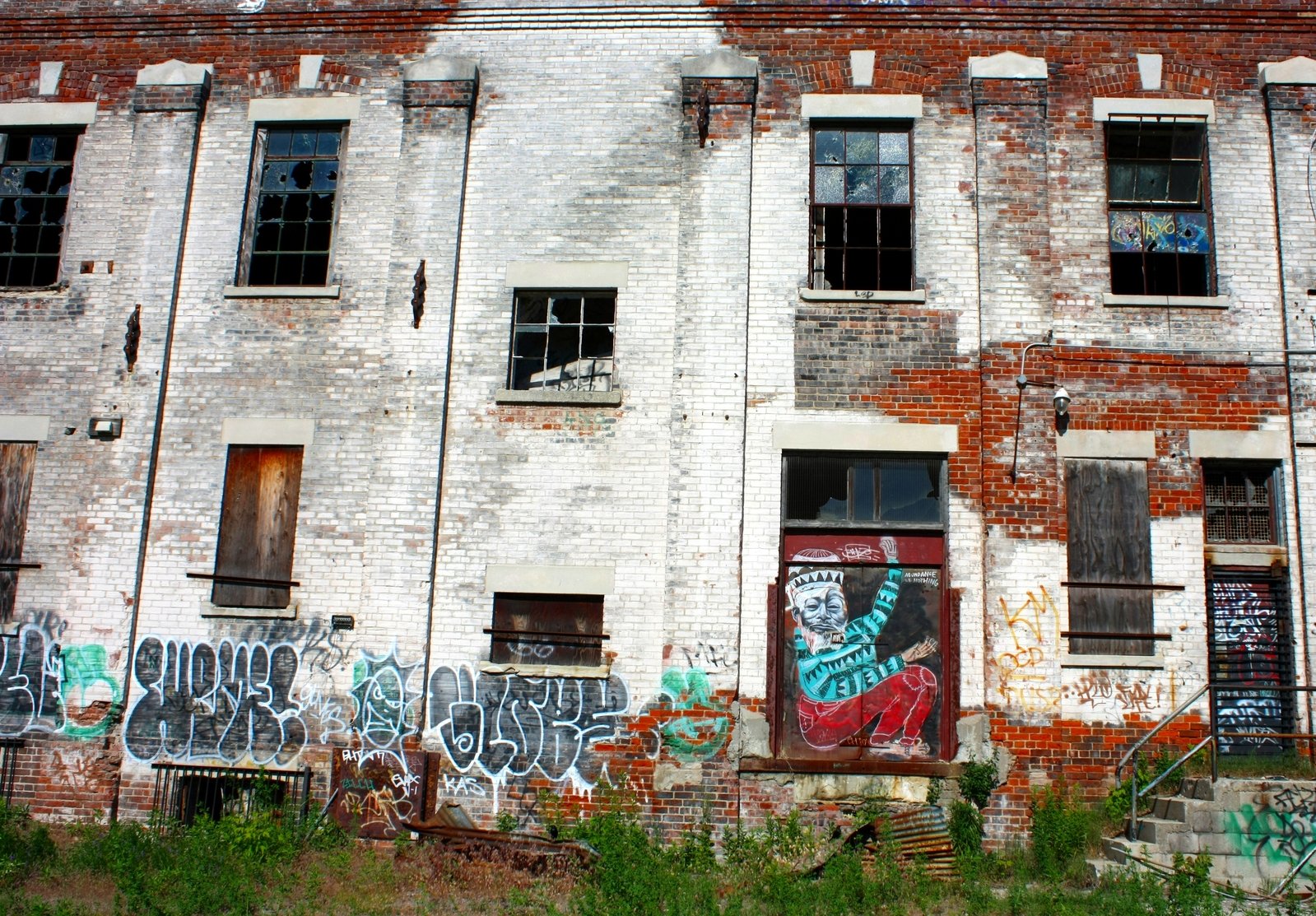 the buildings are boarded up and decorated with graffiti