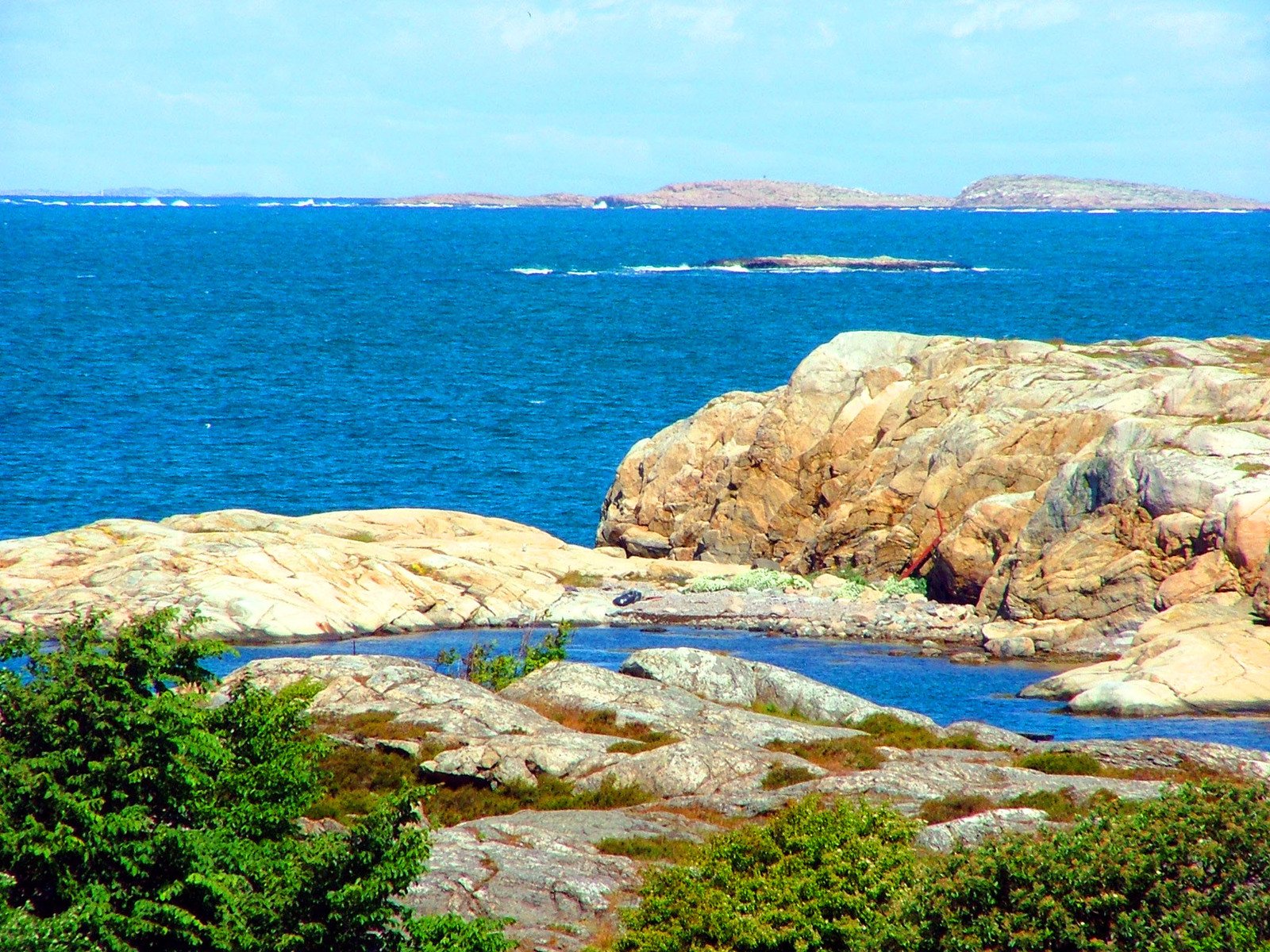 a large body of water surrounded by rocks and a shore