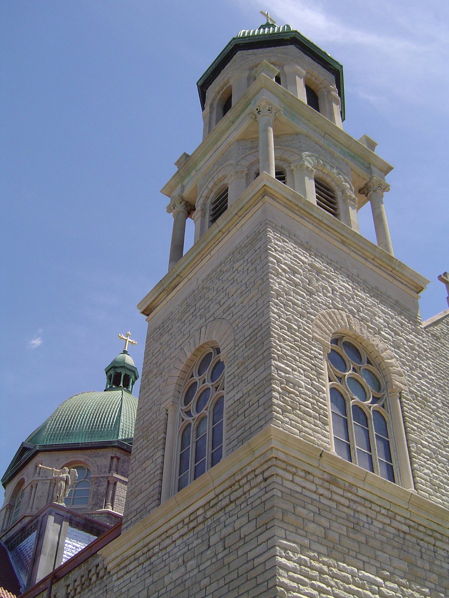 a close up of the top of a building with a cross and steeple