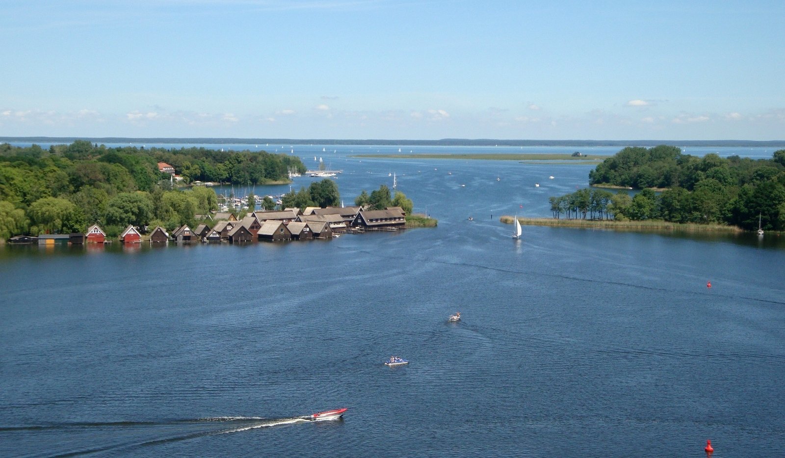 an island that has a harbor that has boats and houses along it