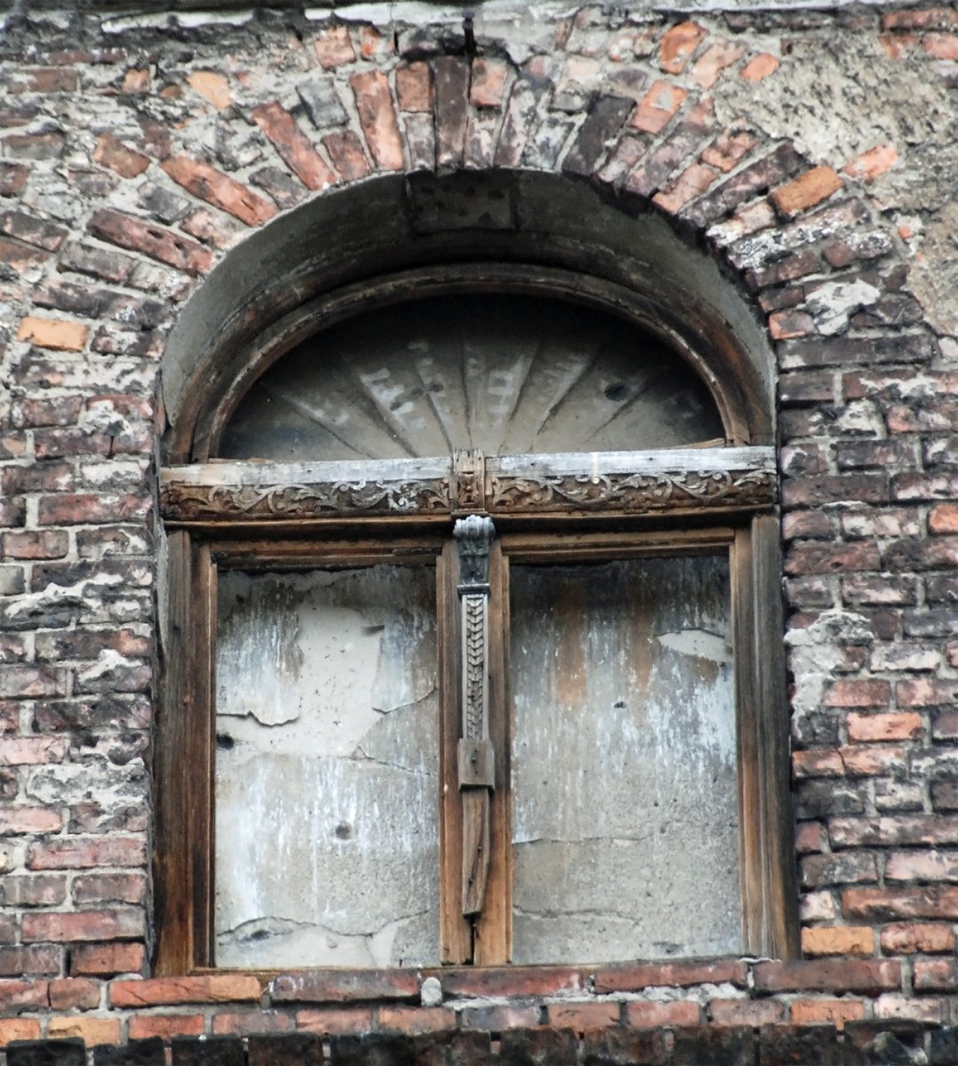 an old door on the side of an empty building