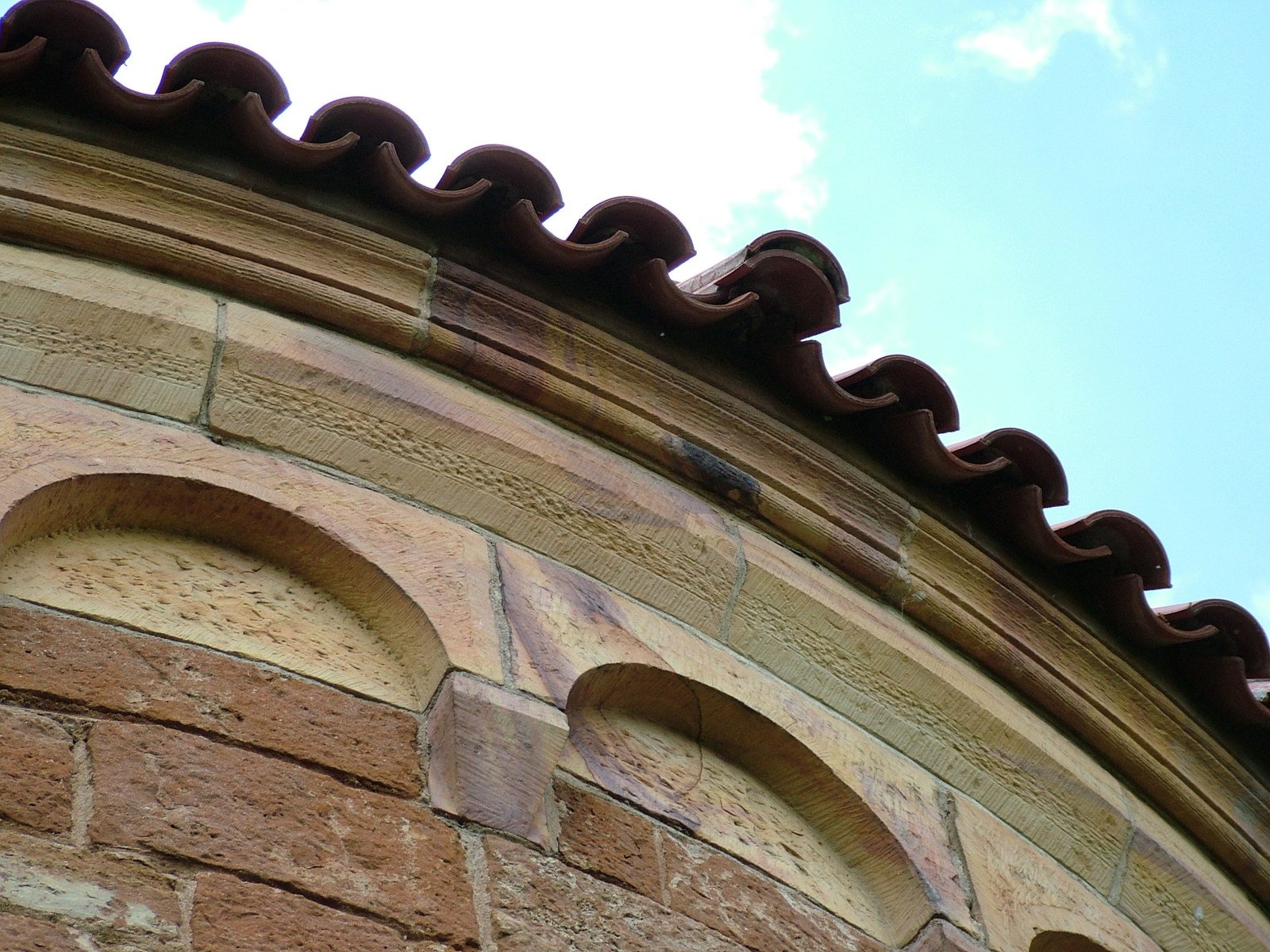 looking up at the top of a wall that has a round arch