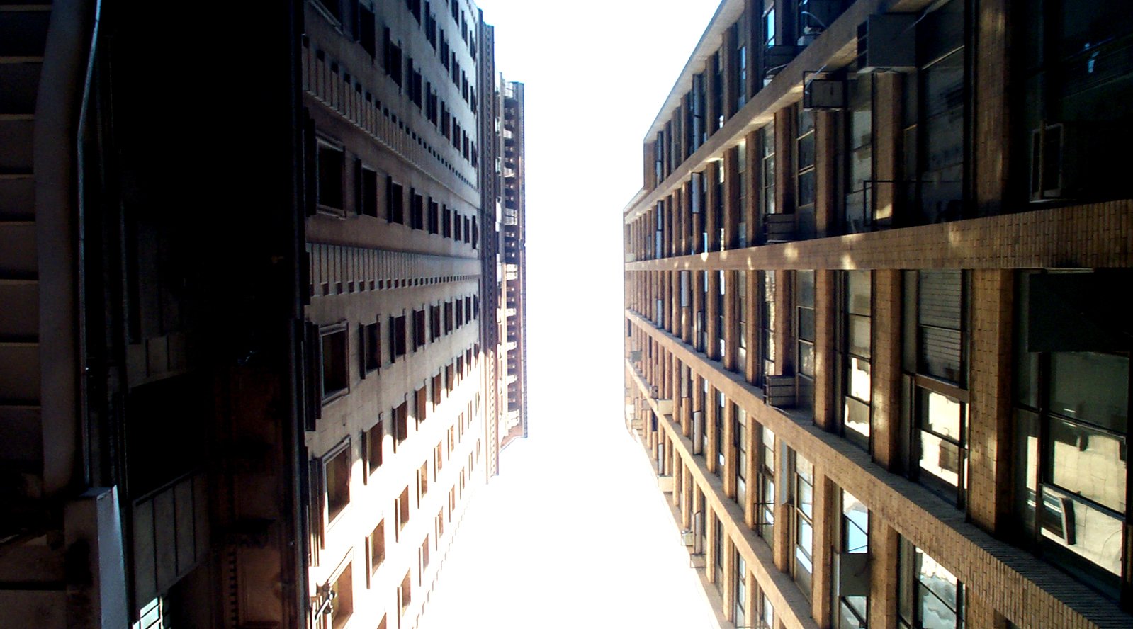 a long narrow building street with very tall buildings