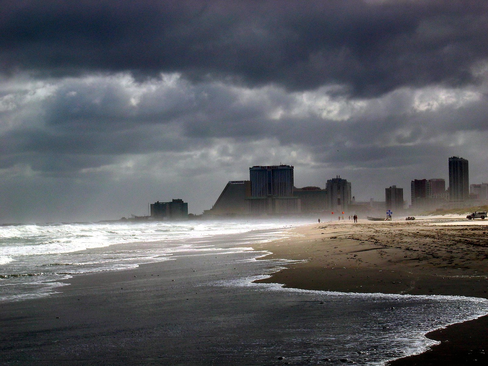 storm clouds hover over a skyline and the shore