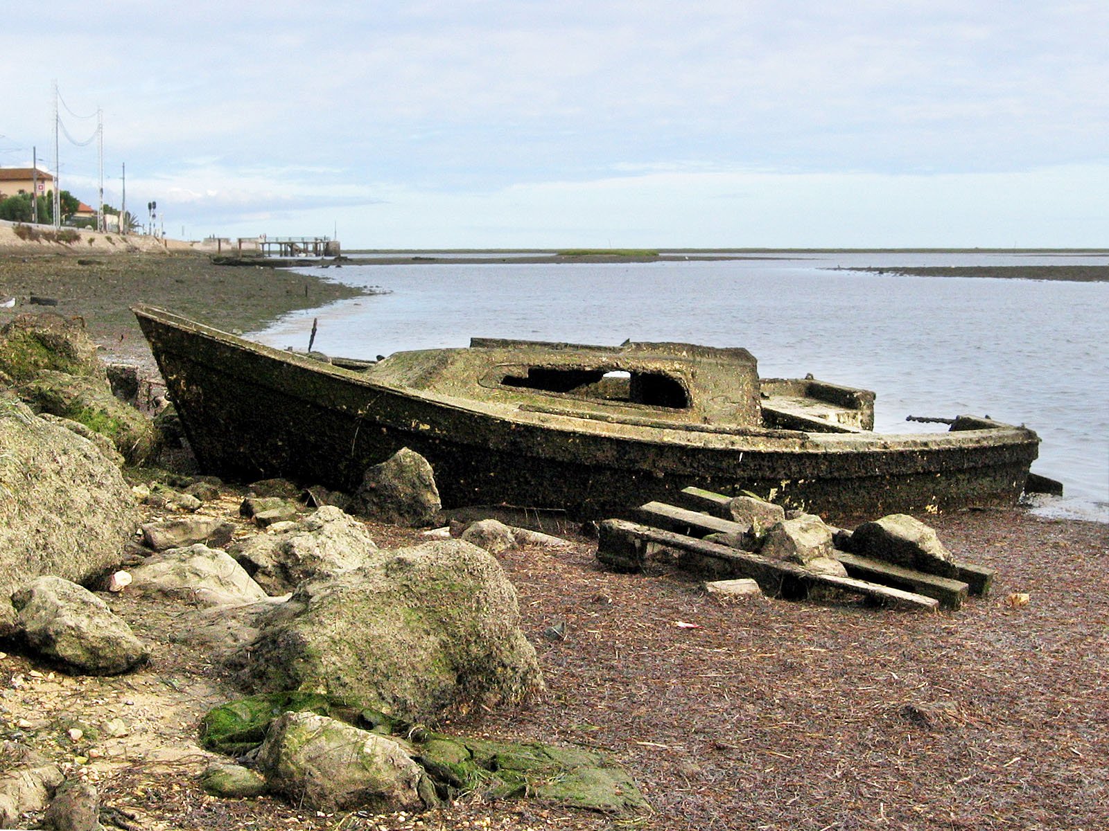 a boat on the shore by the ocean