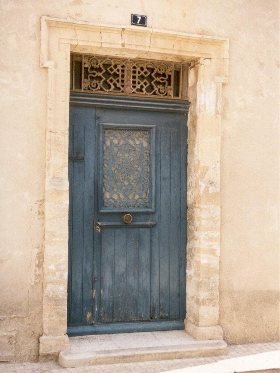 a blue door and window frame on a white building