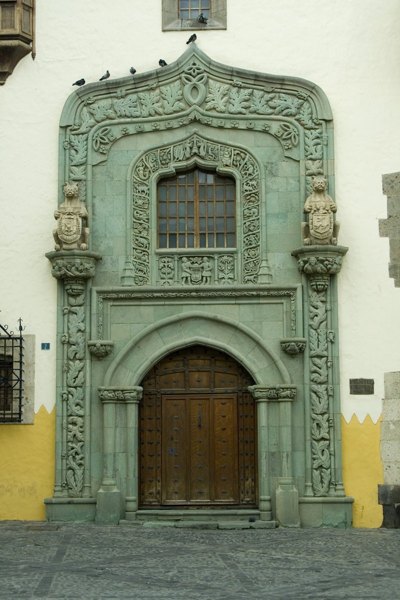 two brown doors are in front of a green facade