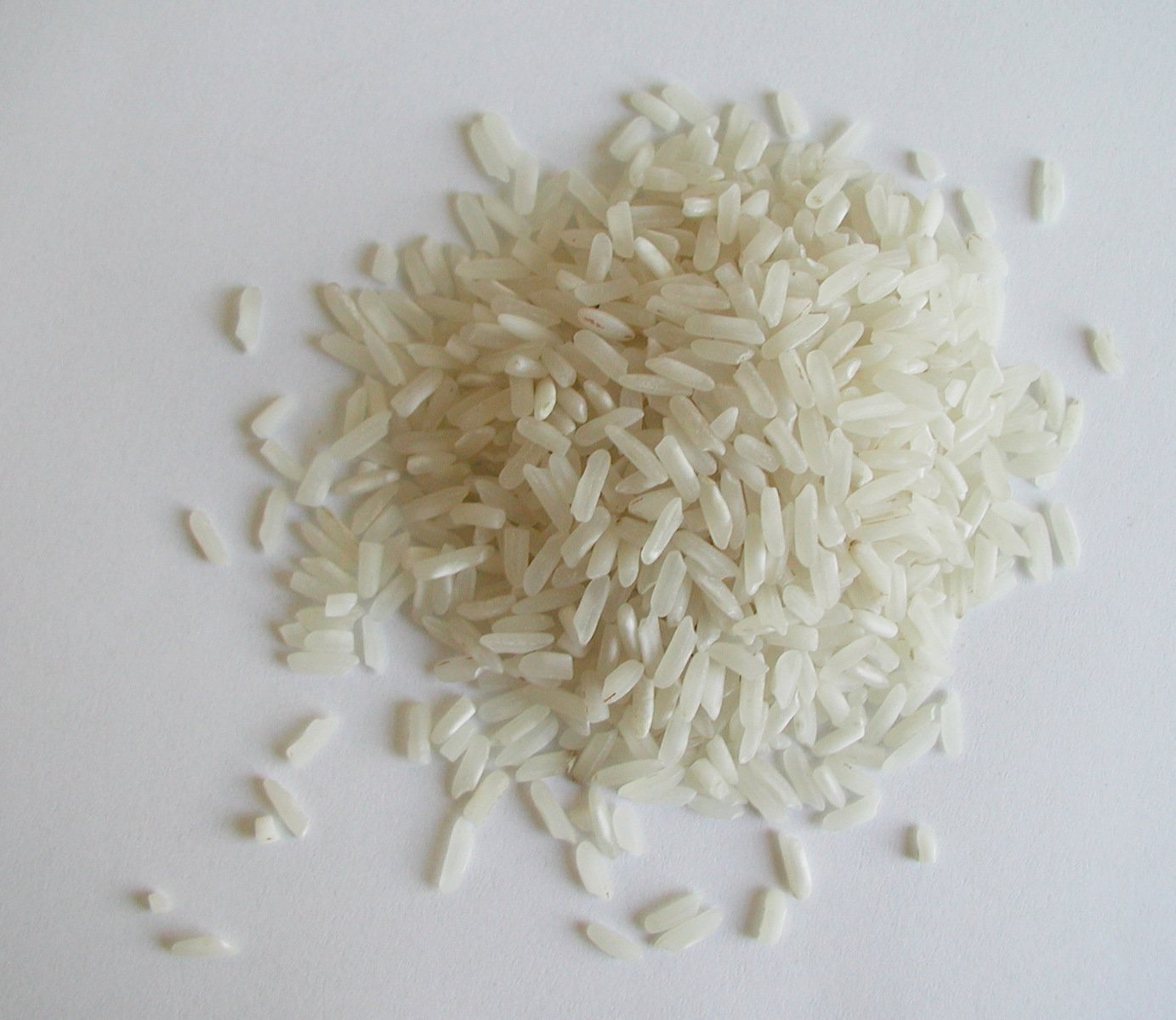 rice scattered on white surface next to food item