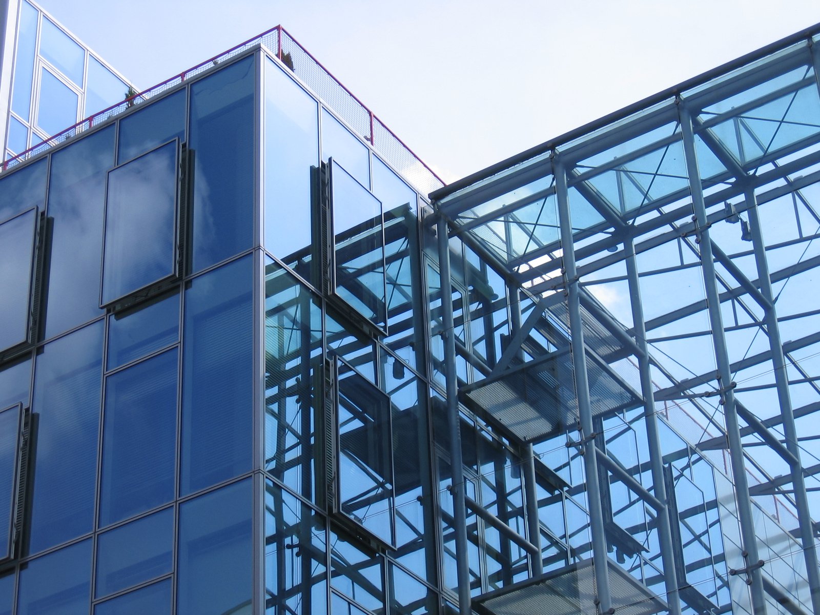 the top part of two office buildings with sky in background