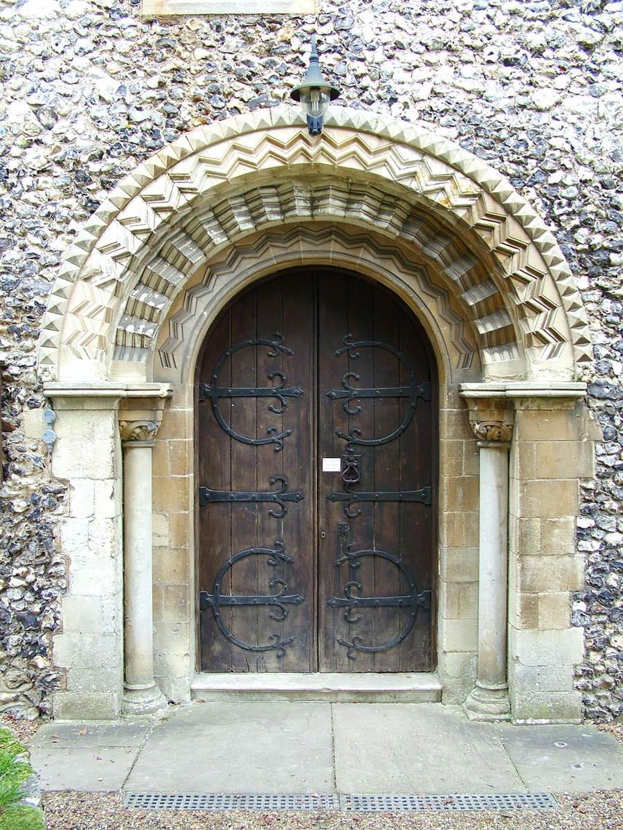 a very old stone building with two large brown doors