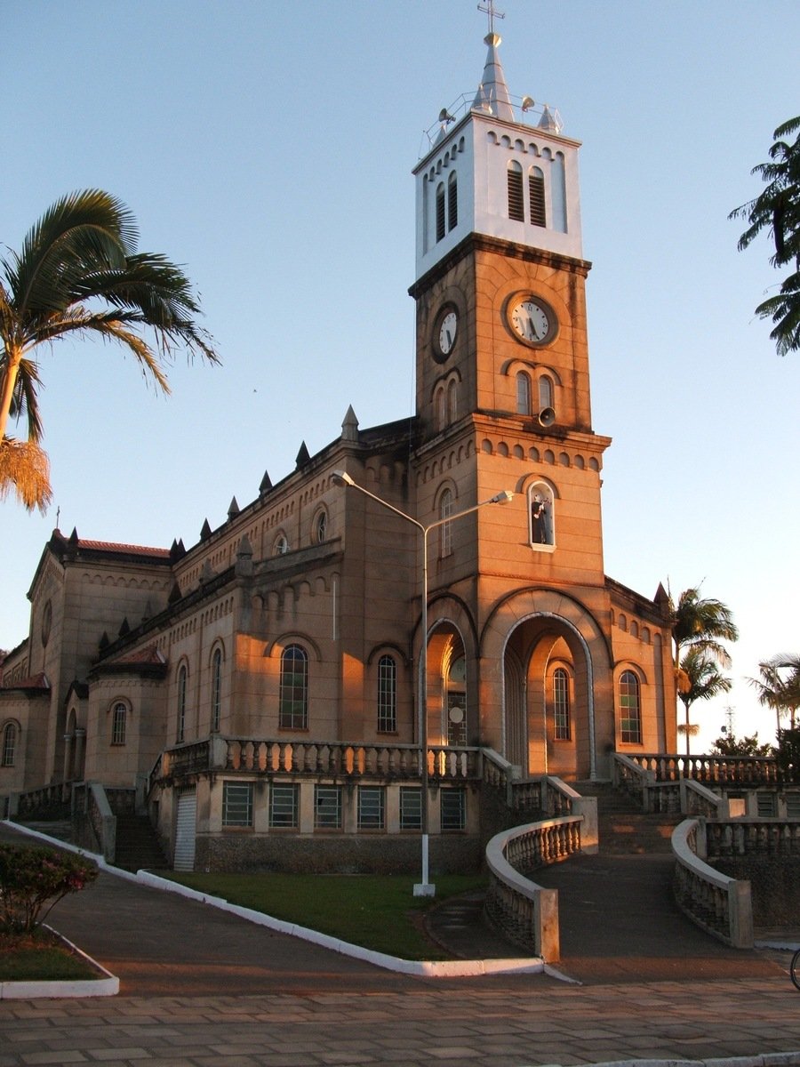 an old, large building with a clock tower sits in the middle of a town