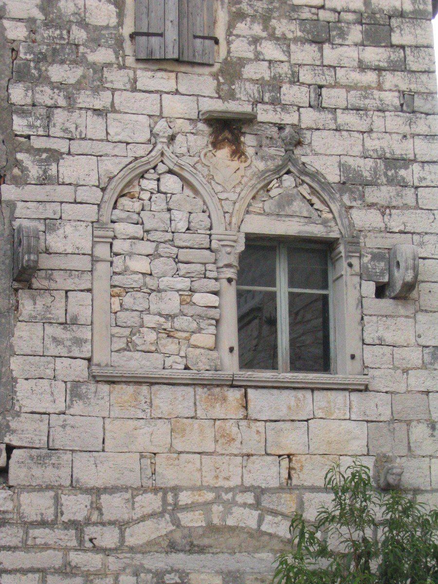 an old building with a small window and broken bars