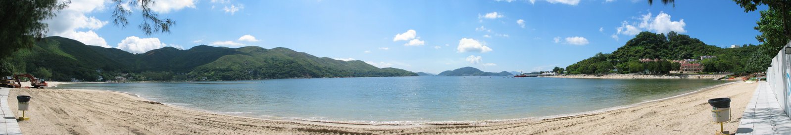 a beach with people on it with boats near by