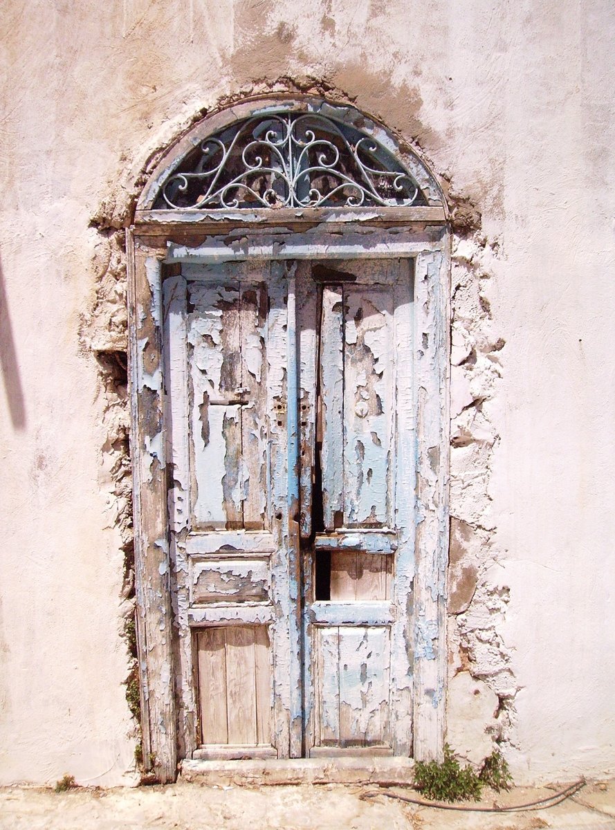 old door on stone and stucco building with decorative arch top