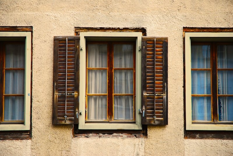 three windows that have a wooden frame with some windows