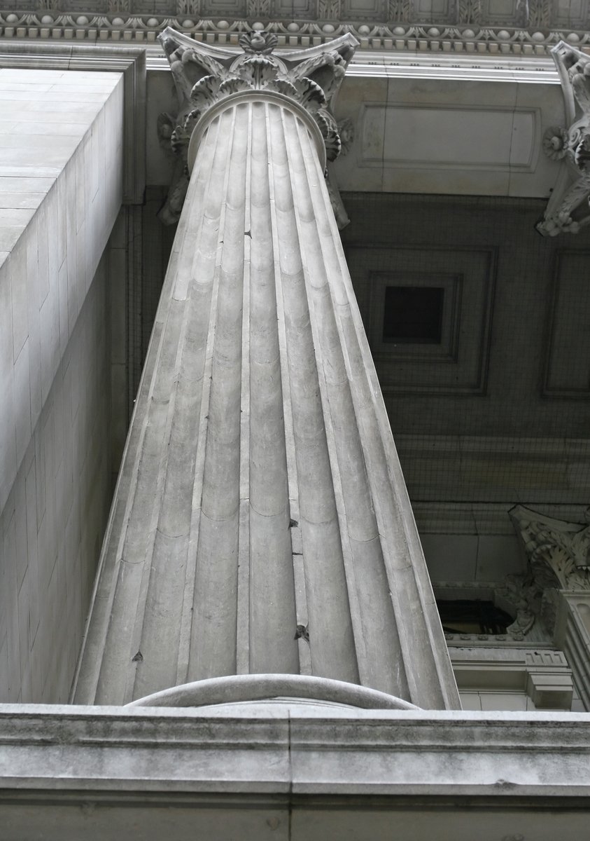 the view looking up at the columns and ceiling of the building