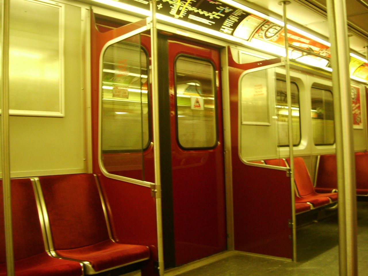 an empty metro train car with red seats