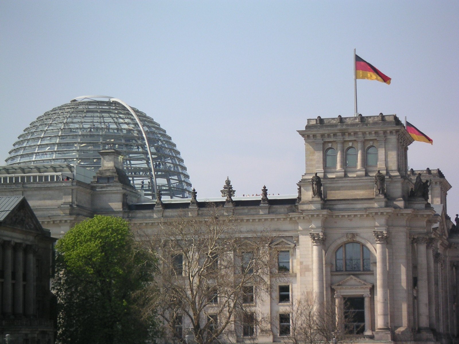 an ornate building with two huge domes sits next to trees