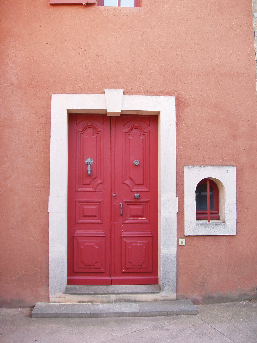 red doors are on the side of a red and white building