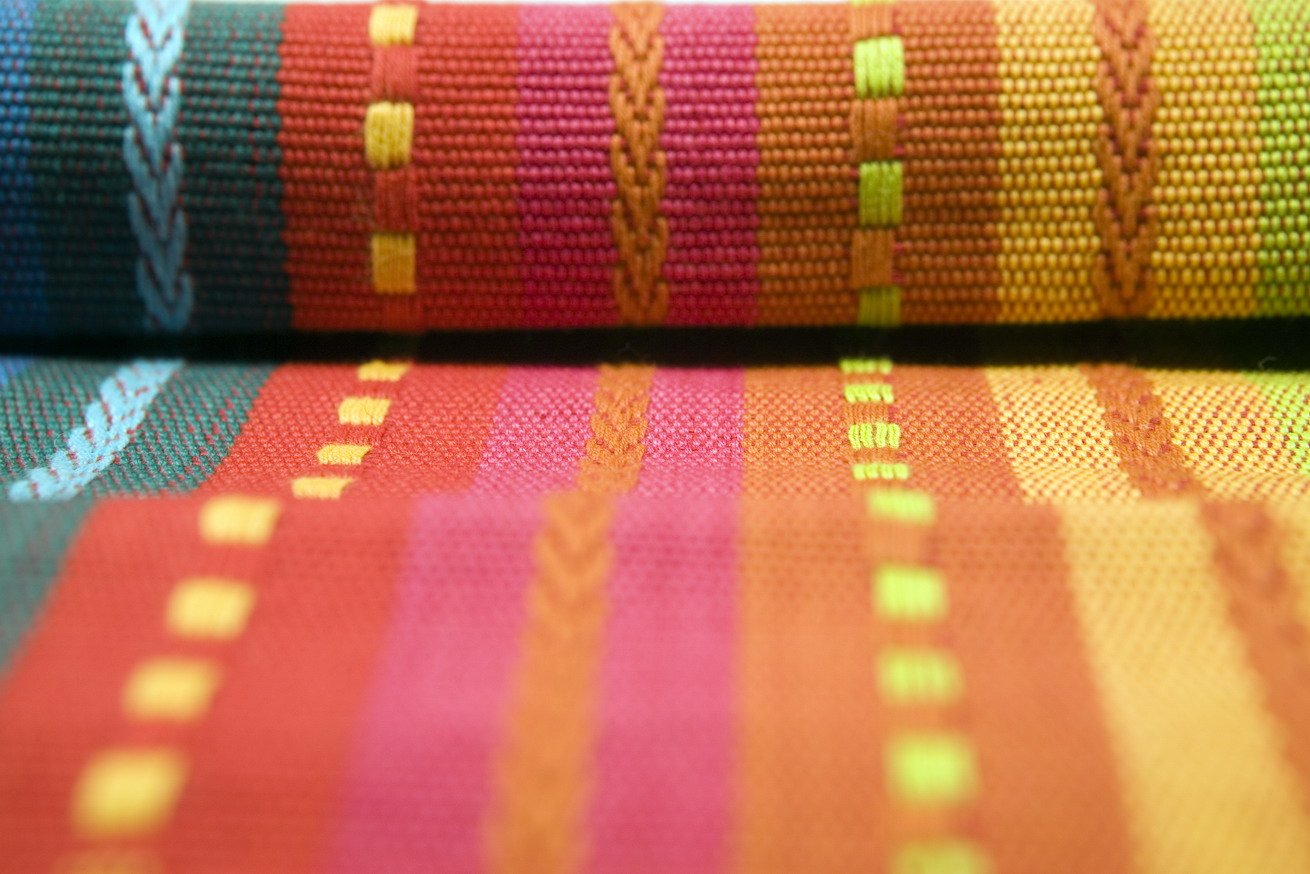 a red orange and yellow scarf laying next to each other