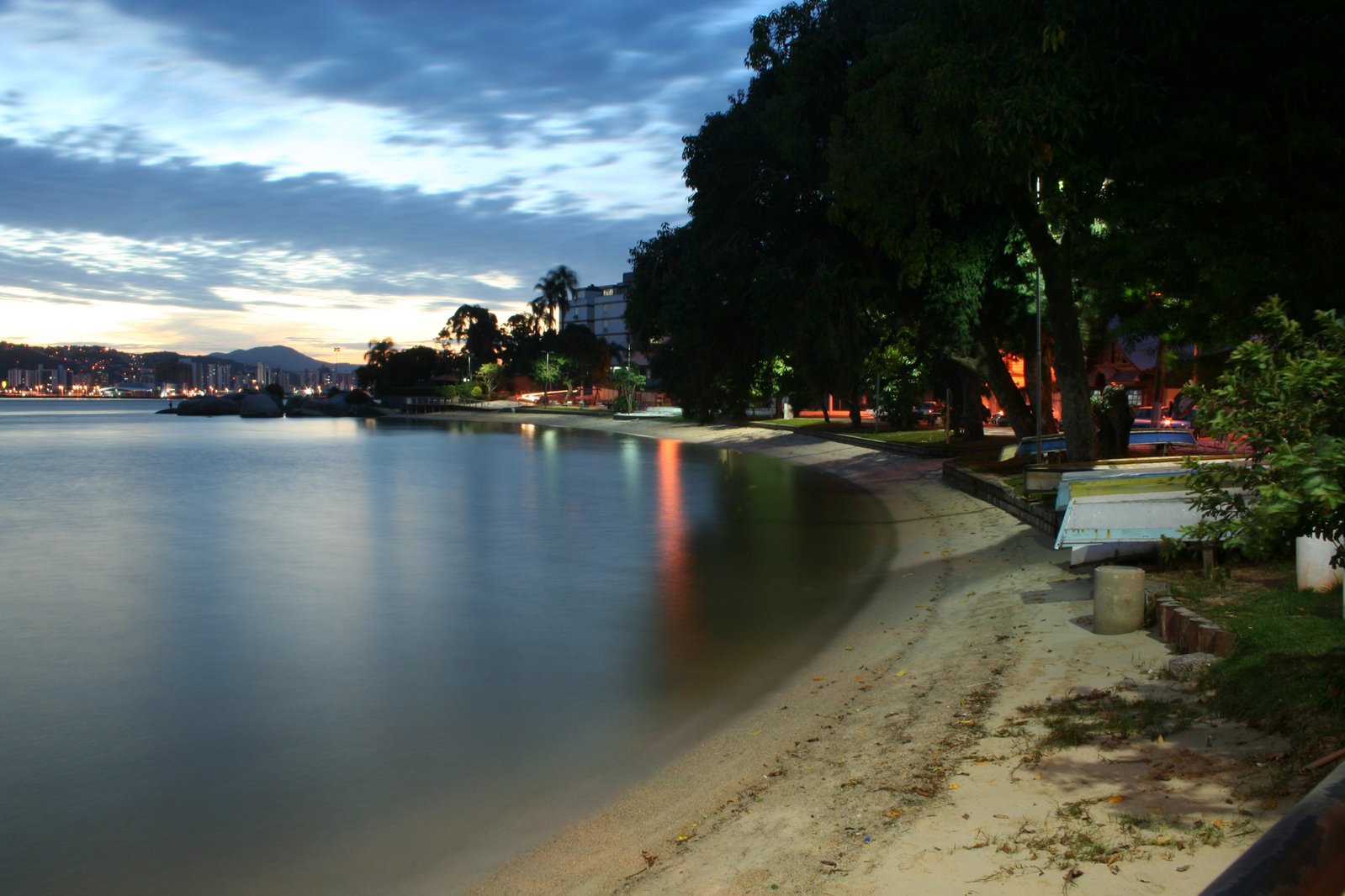 night scene of the ocean, with a lone bench