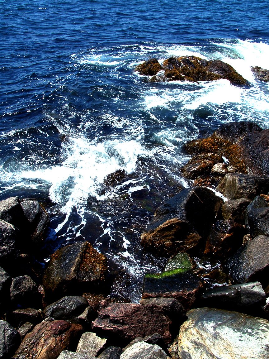 several rocks in the water near some water