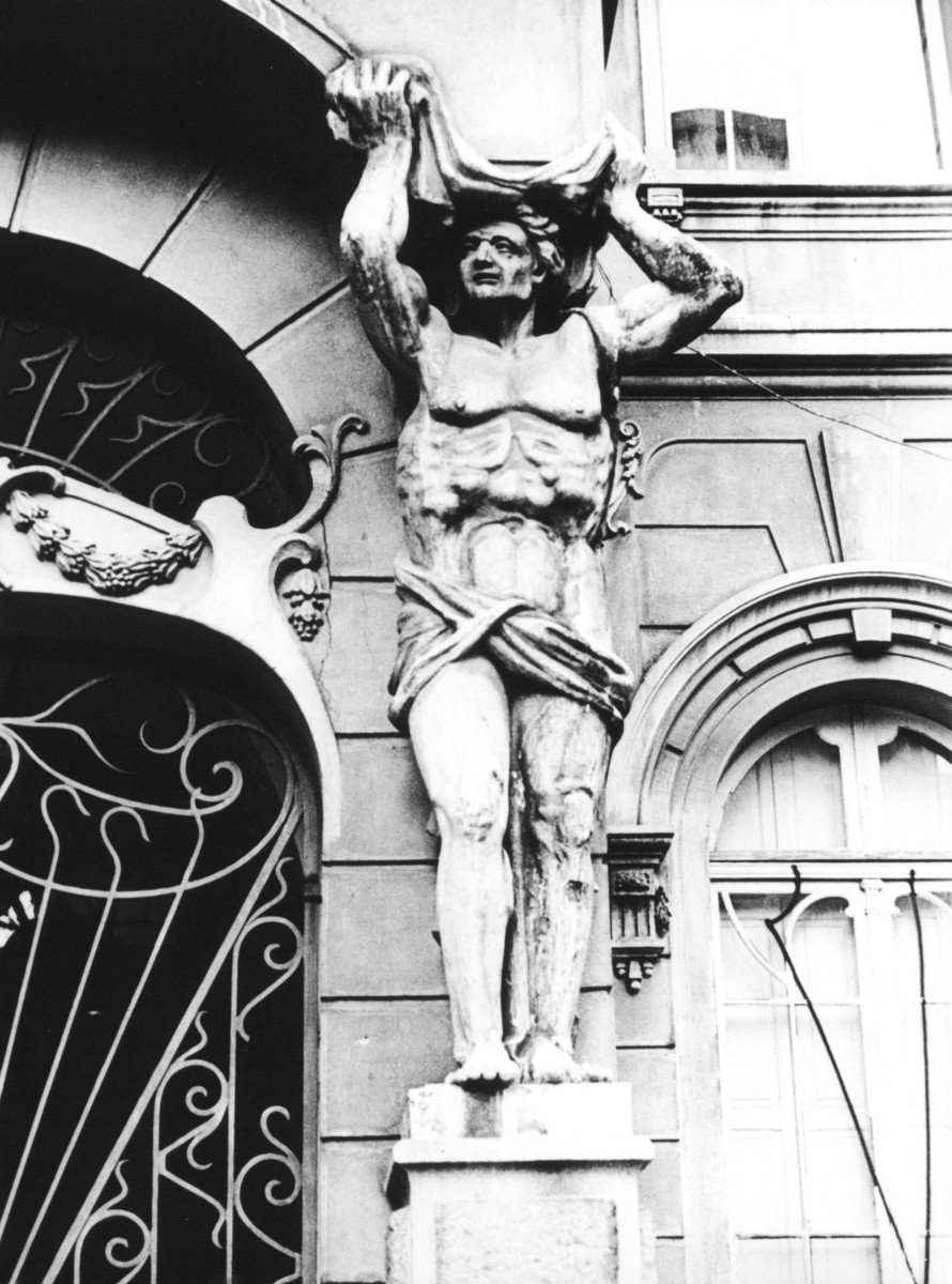 a statue of a man standing in front of a building