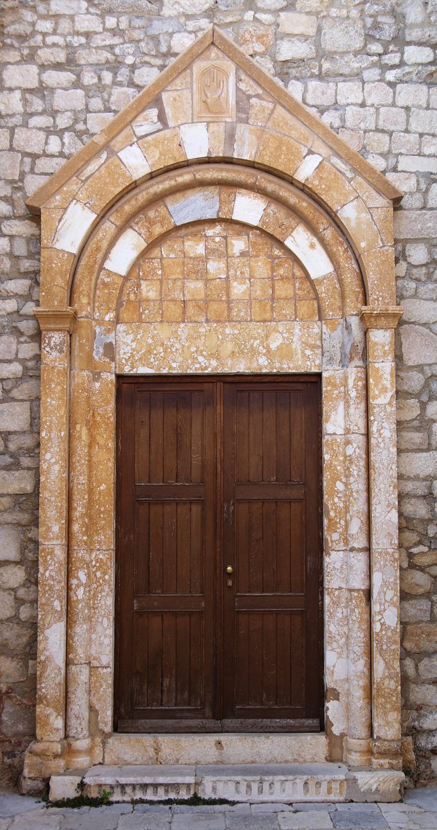 two brown doors in front of an old stone building