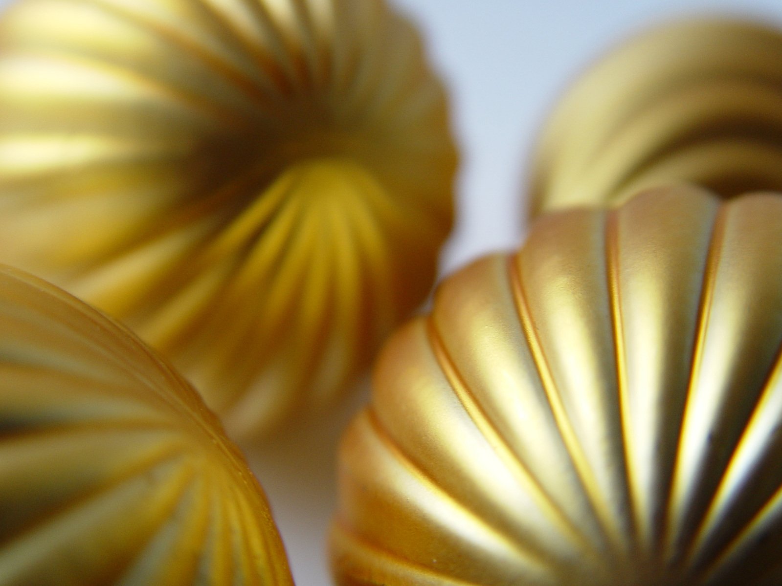 three shiny gold pieces in a cluster with a white background