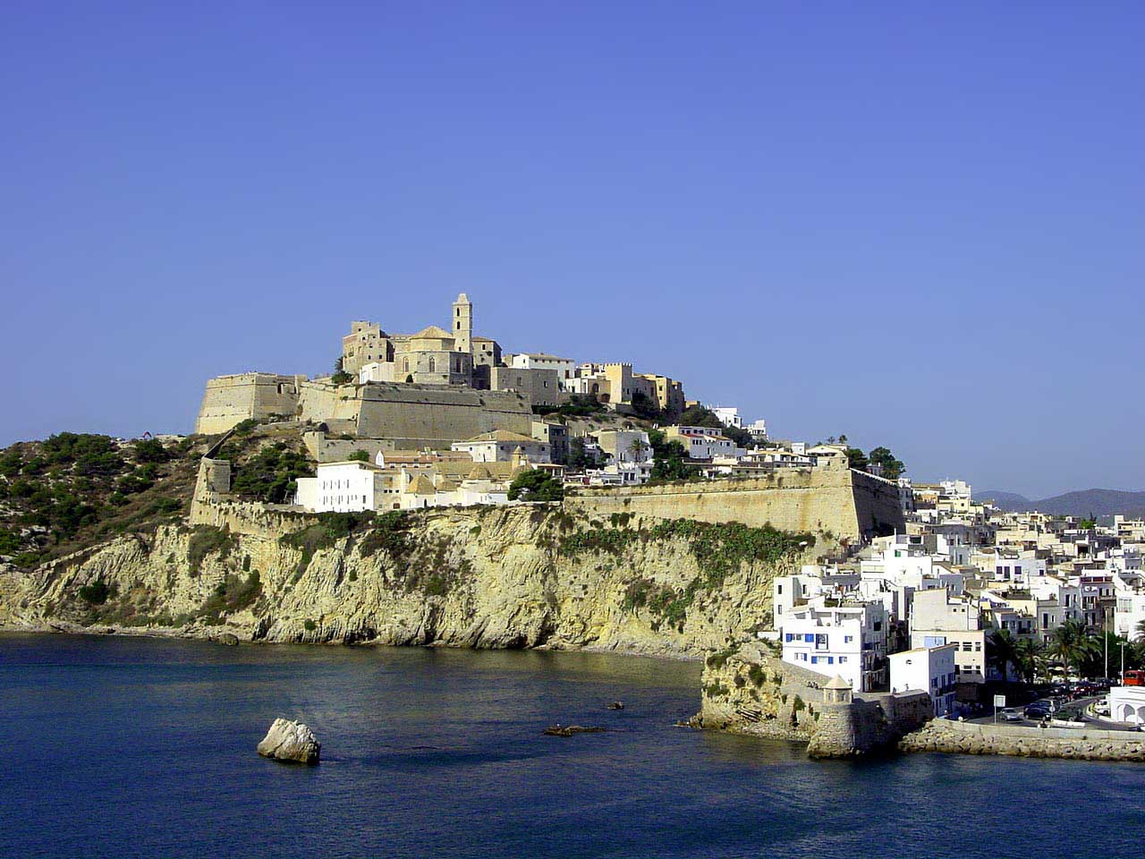 an island sitting on top of a cliff next to the ocean