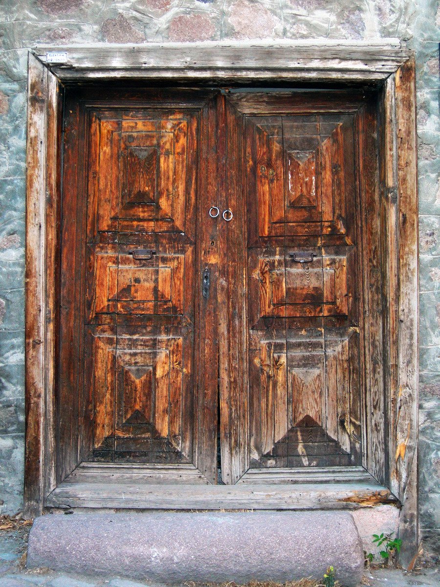 an old, wood door with some graffiti on it