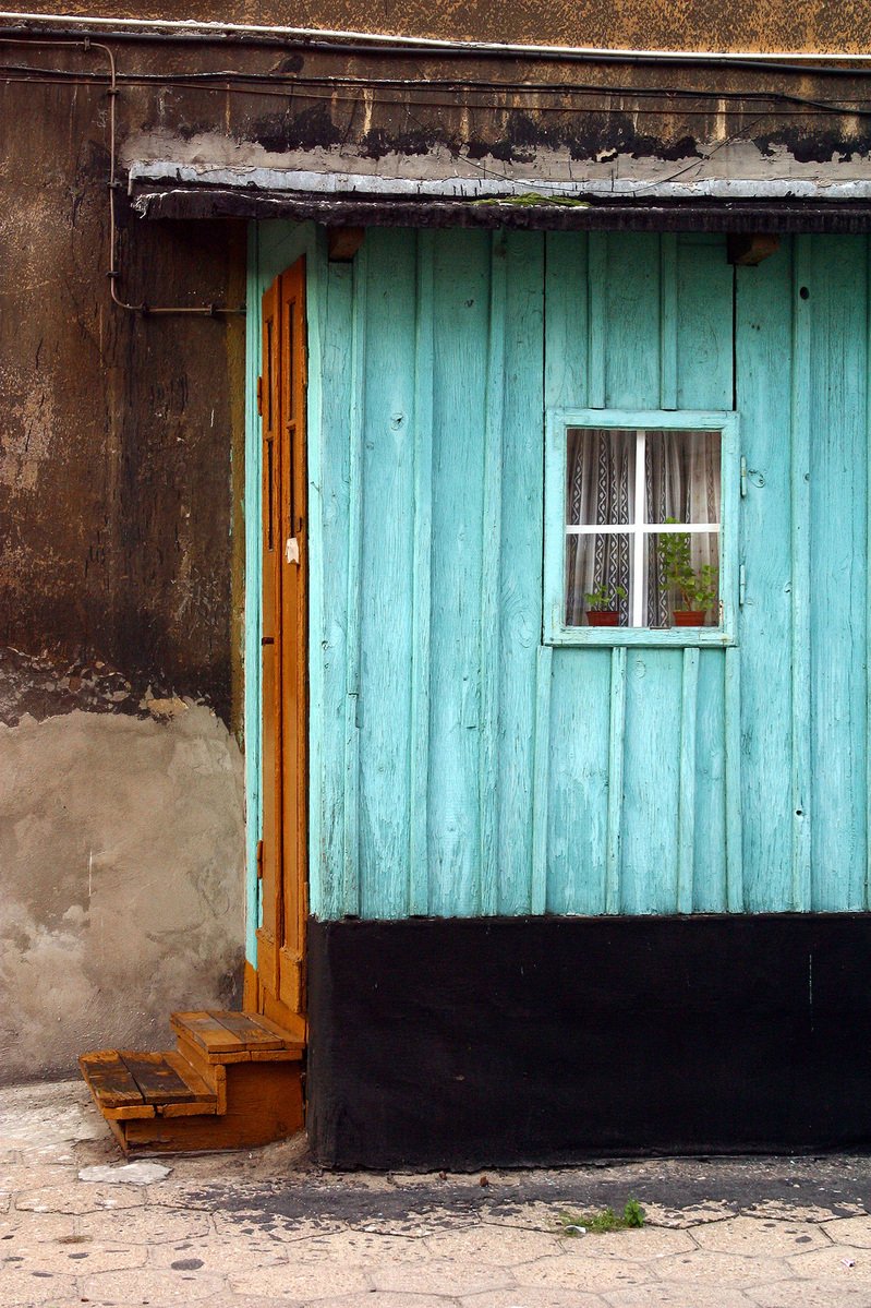 there is a blue building with a window on the corner