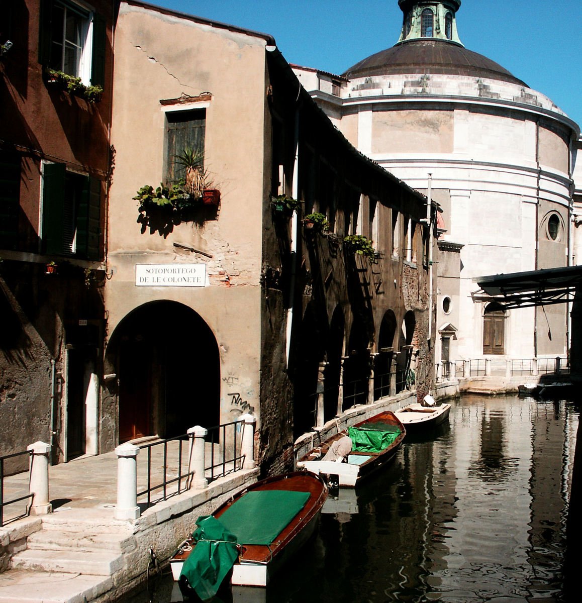 several boats are parked in the canals near buildings