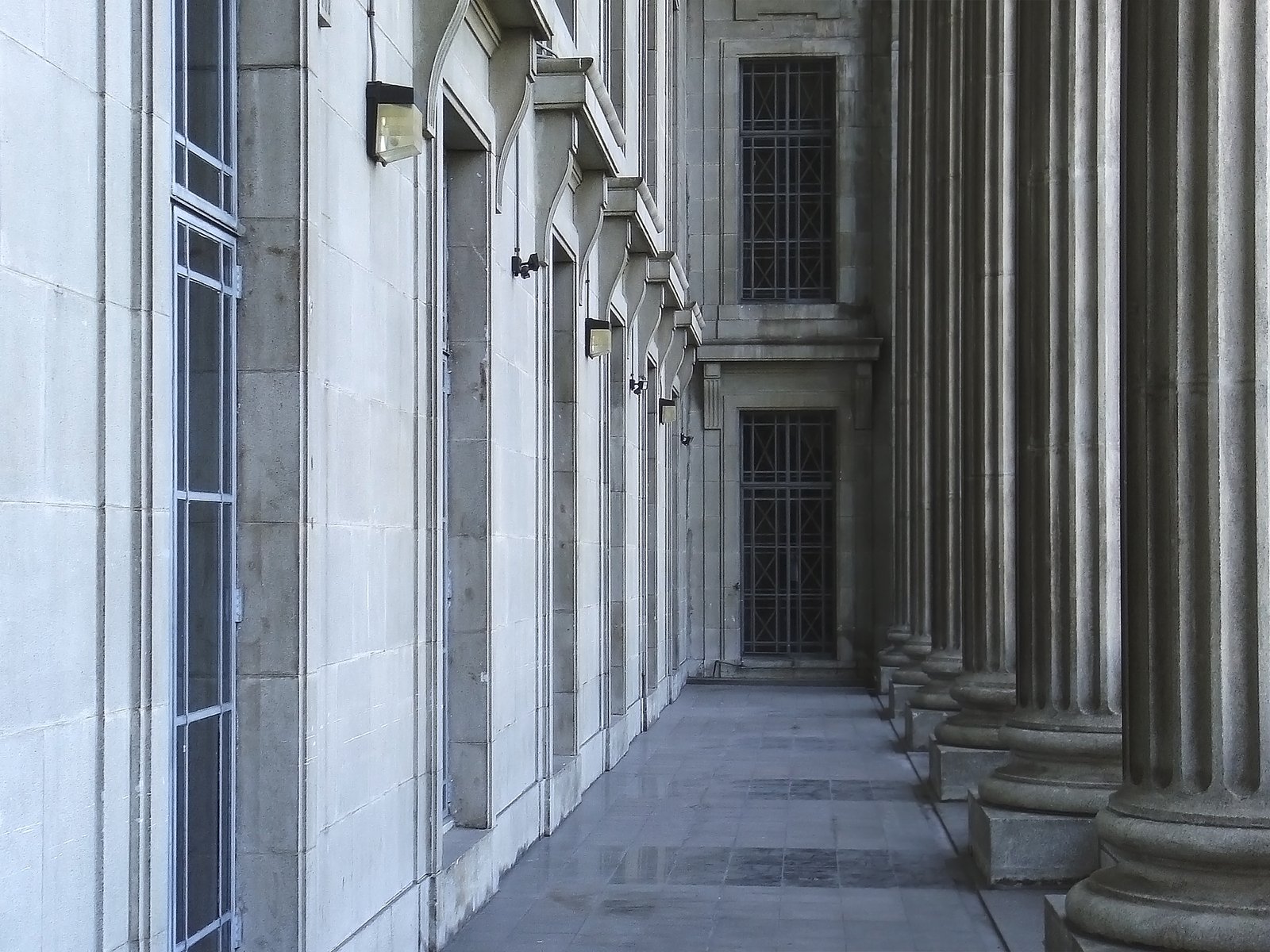 an empty corridor in a building with columns