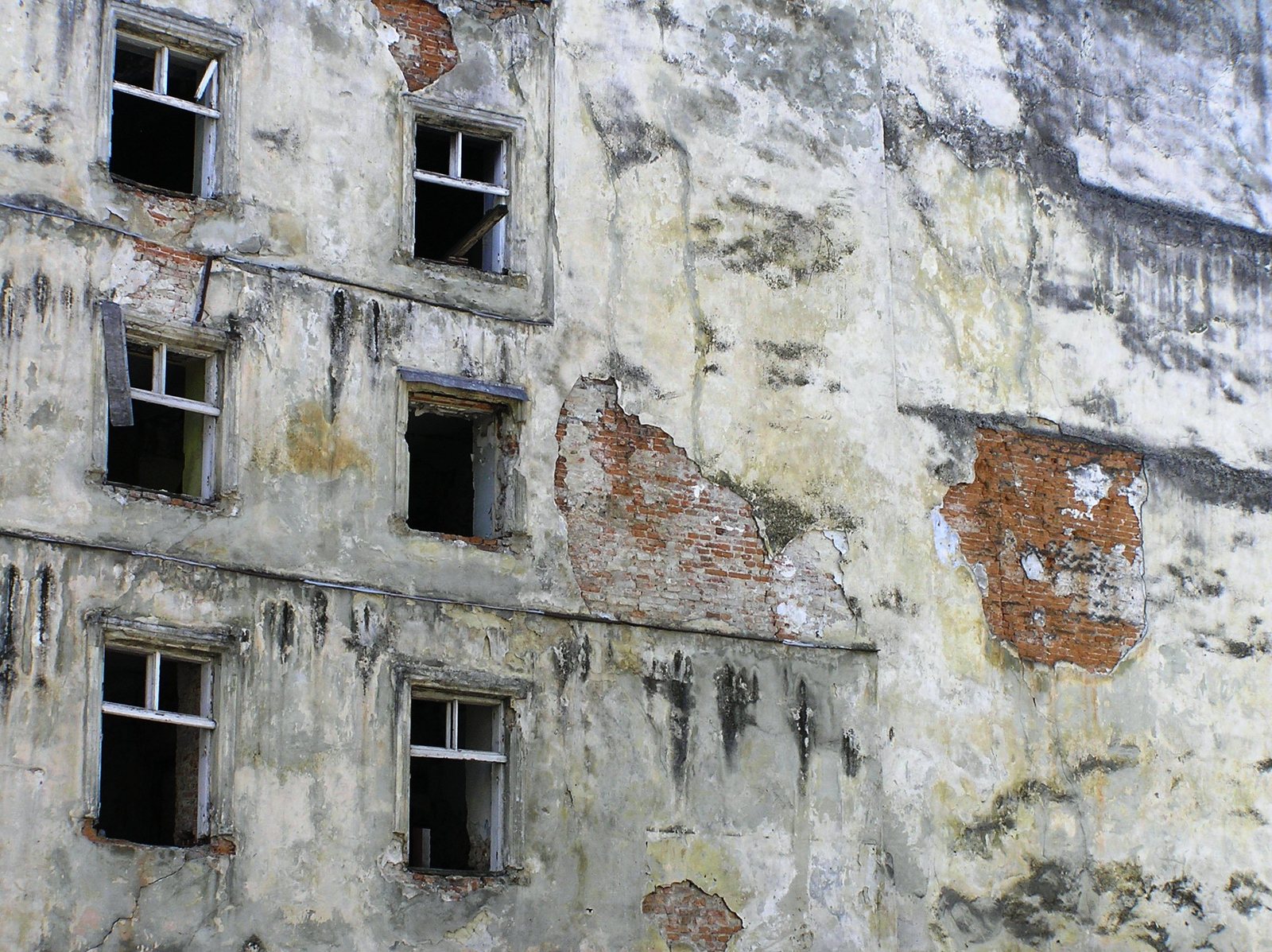 two old windows that are near some wall