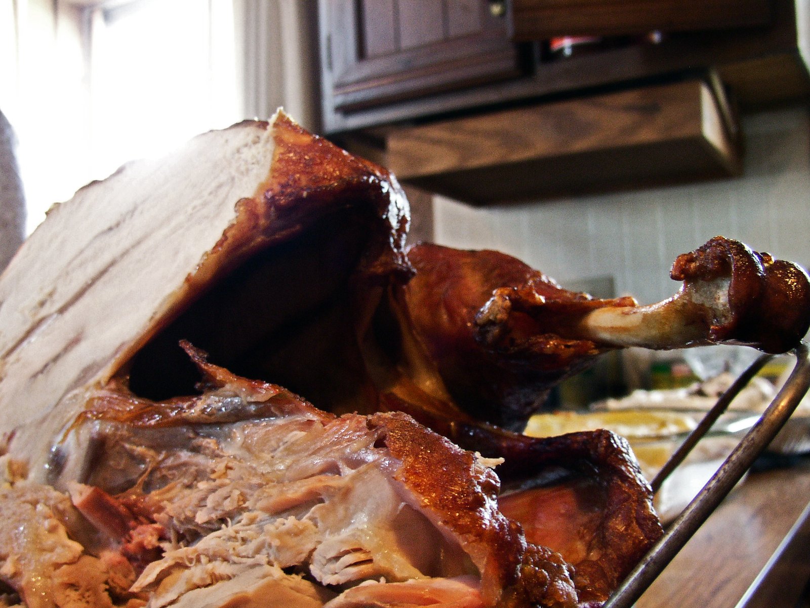 a meat roast is on the grill while a person looks over