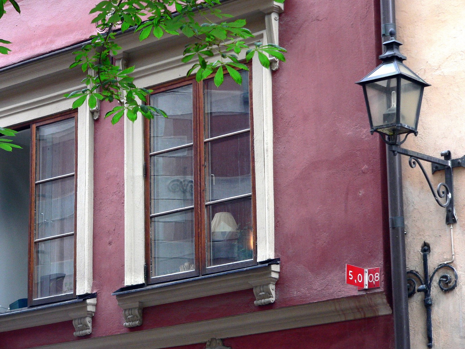 a large brown building with some windows and a red street sign