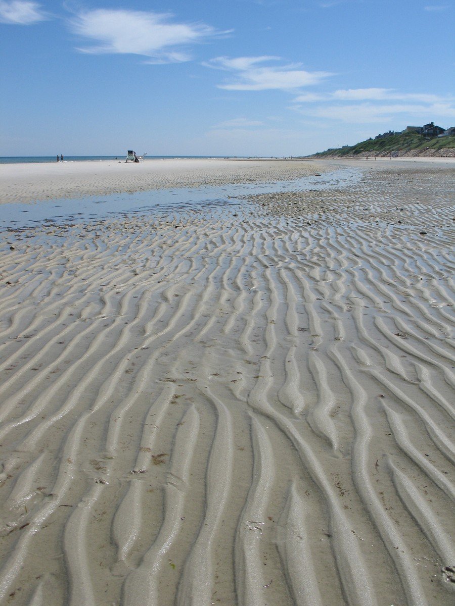 a view of a sandy beach with waves and sand