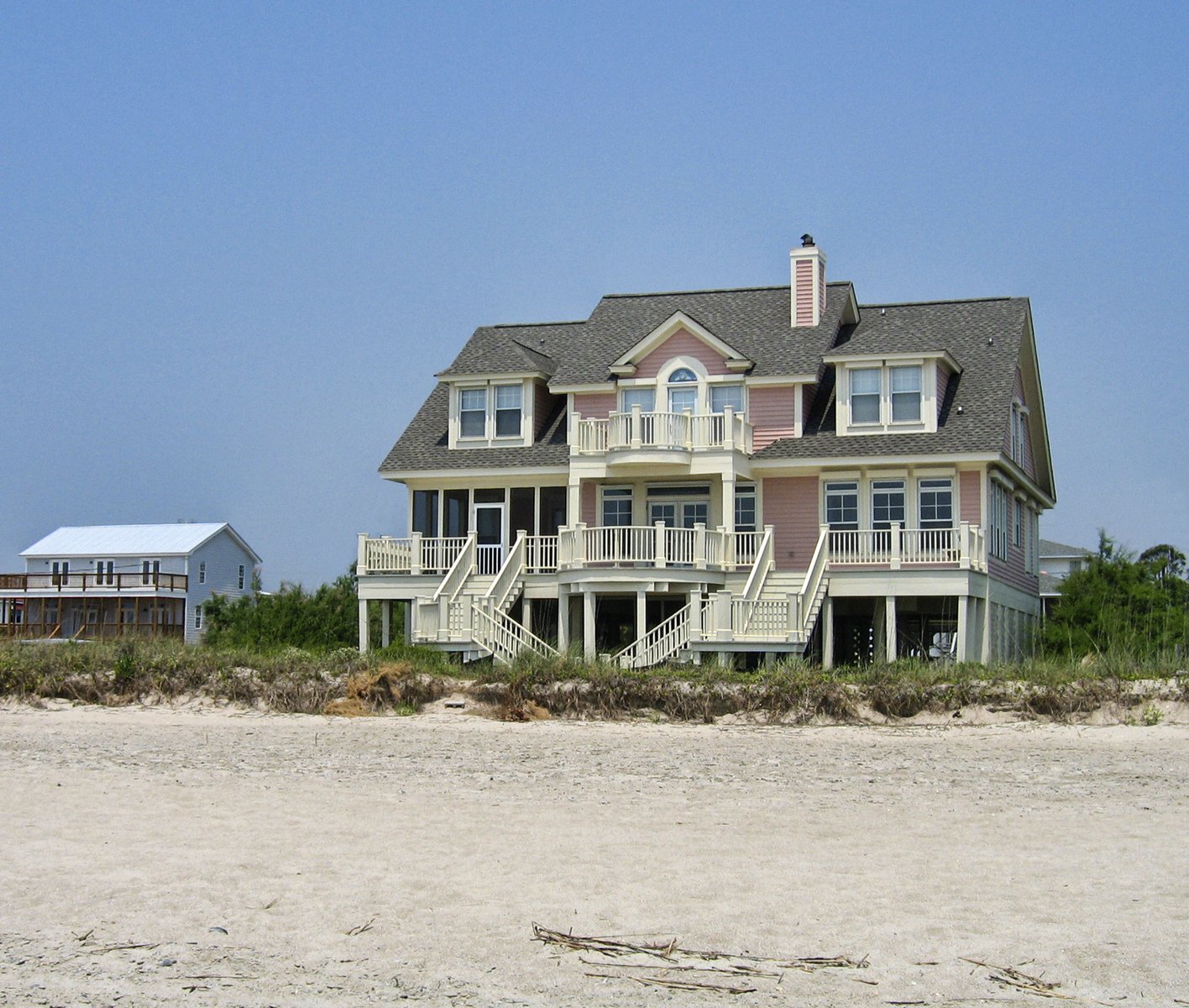 a beach with sand in front of the house