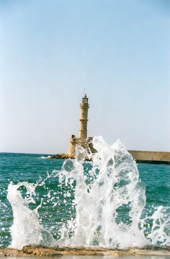 some water a lighthouse and a large wave