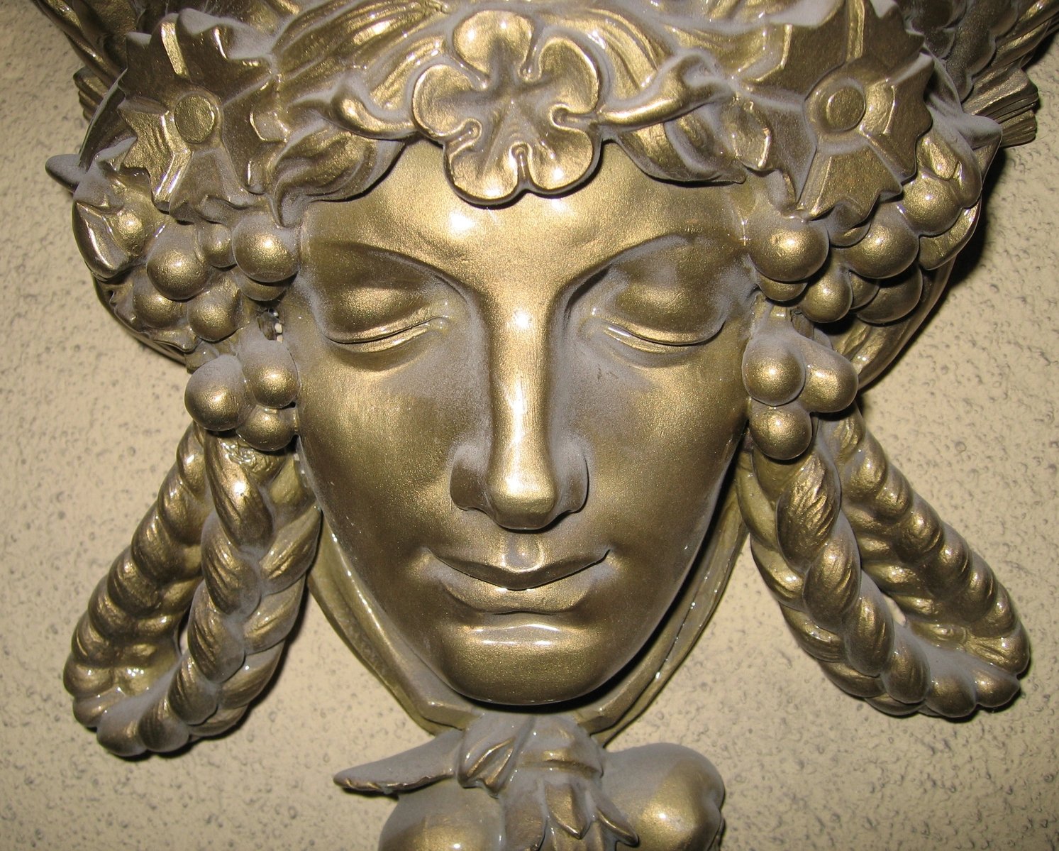 closeup of a metal sculpture with a woman's head in the center