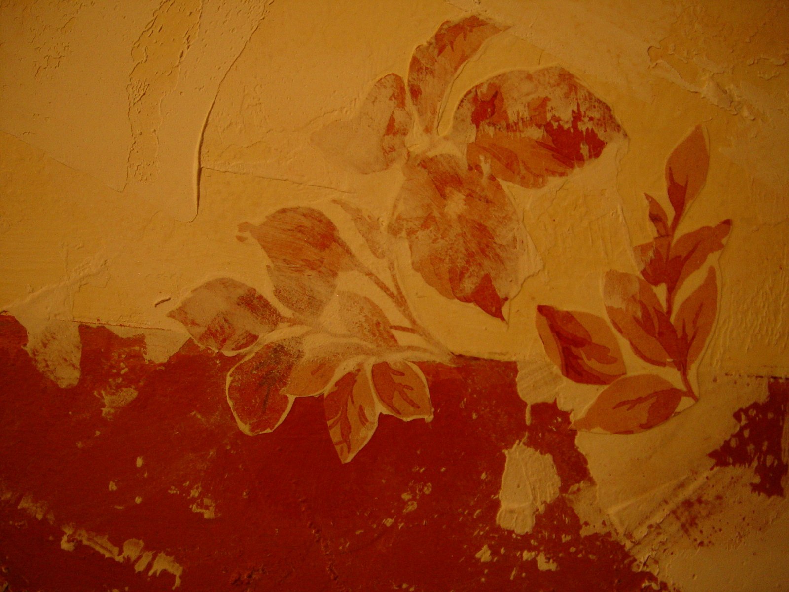 an artistic painting is on the wall and has leaves painted