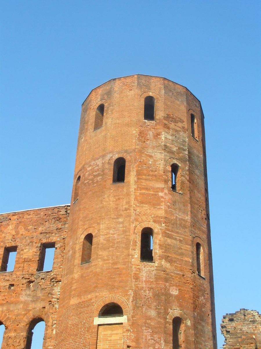 the tower of a stone building that appears to have round windows