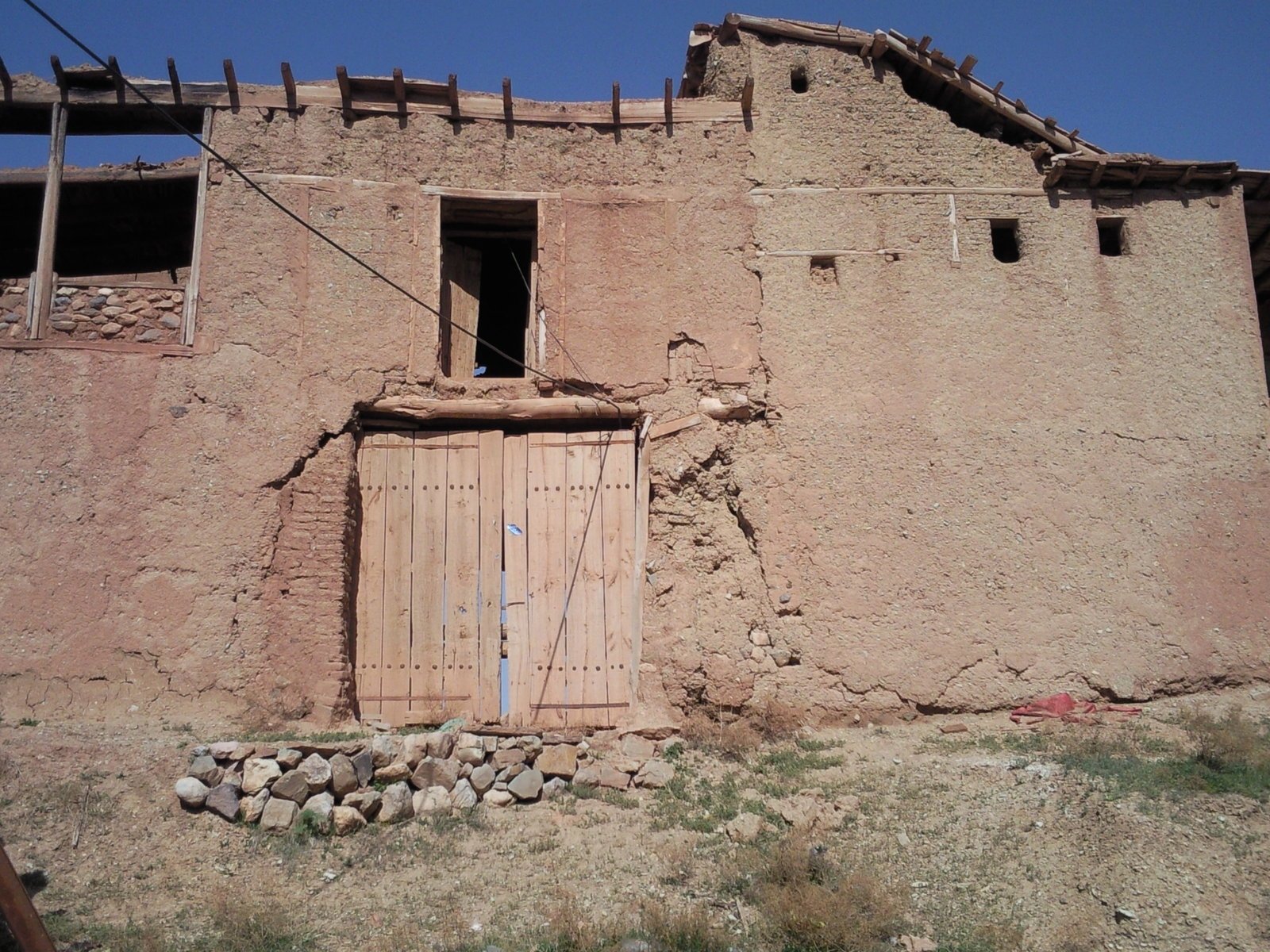 an old adobe building with a large door